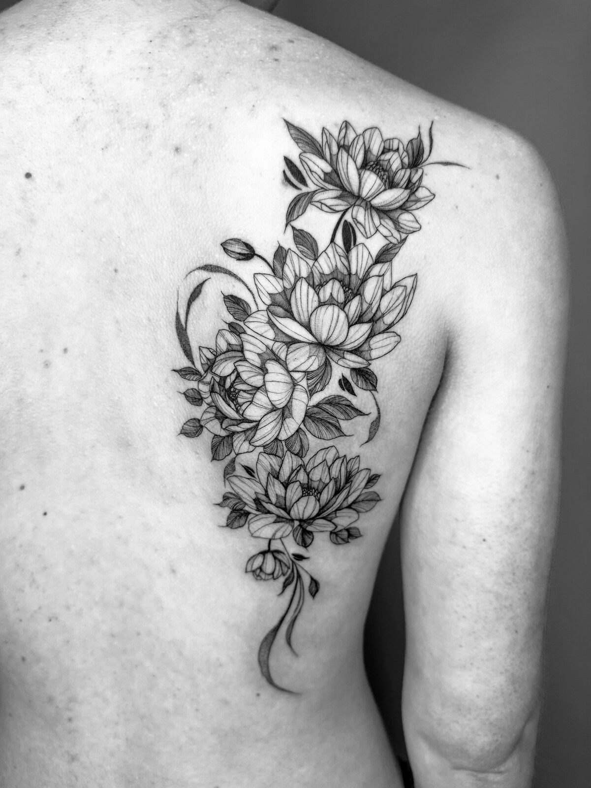 Composition florale fine line sur l'épaule et le dos