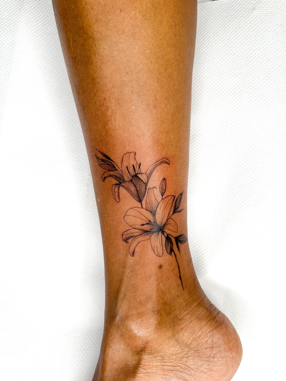 Tatouage floral fine line sur la cheville